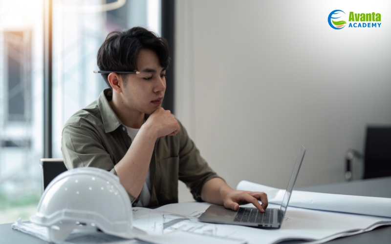 working with laptop and blueprints